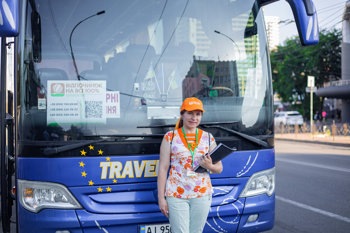 Гід туру з папкою біля автобуса Travel Star